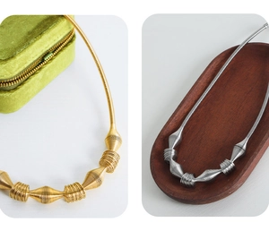 Detailed close-up of woven metallic spindle pendants in gold and silver finishes