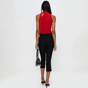 Rückansicht eines roten Neckholder-Tops mit Bindeband und schwarzer schmaler Caprihose