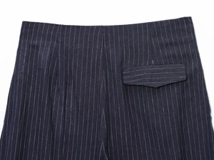 Detail of rear waist and flap pocket on striped linen blend balloon trousers in navy