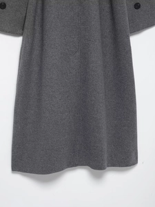 Detail view of dark grey wool coat featuring black buttons and textured fabric finish