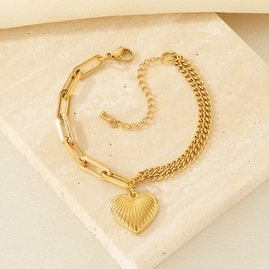 Detail of 18K gold plated toggle link bracelet featuring a heart pendant on stone