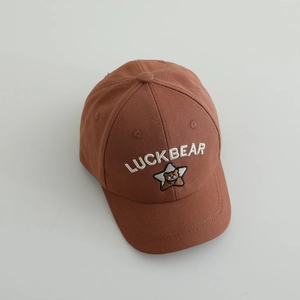 Détail de la casquette caramel avec broderie Luckbear et écusson étoile enfant