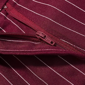 Macro shot of high-quality burgundy striped fabric and durable zipper closure detail