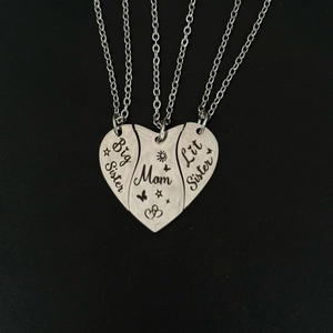 Detailed view of 3-piece silver heart puzzle necklaces with Big Sister, Mom, and Lit Sister text