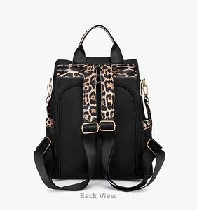 Detail view of the black backpack's back side showing adjustable leopard print straps
