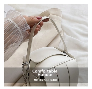 Detail showing woven leather texture of a white handbag with silver chain and handle