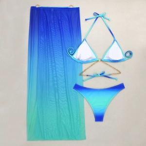 Detail of blue and green gradient mesh long skirt with gold chain bikini set on fabric