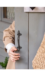 Close-up of seahorse cast iron handle showing rustic texture and curved vintage design