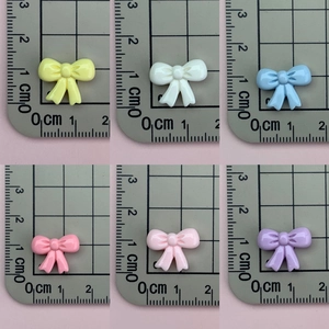 Detailed view of colorful 1.5cm resin bows in six candy colors for nail art and jewelry