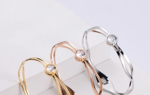 Close-up of titanium steel open bangles with single zircon in gold, rose gold and silver