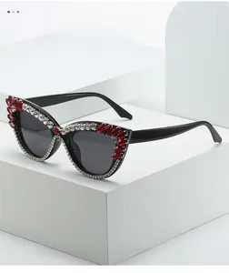 Detail of cat-eye sunglasses featuring red and white rhinestones on black frames