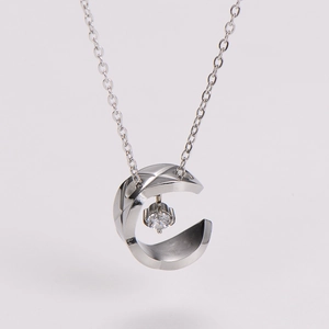 Detailed close-up of C-shaped silver necklace pendant featuring a classic quilted pattern