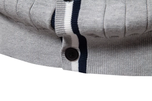 Dettaglio del cardigan in maglia grigia con strisce blu scuro e cuciture di pregio
