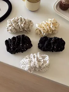 Detailed set of 5 pleated floral and polka dot hair scrunchies on a white surface
