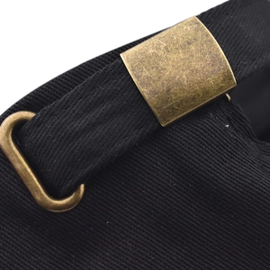 Macro detail of black cotton strap with antique brass metal buckle on a baseball cap