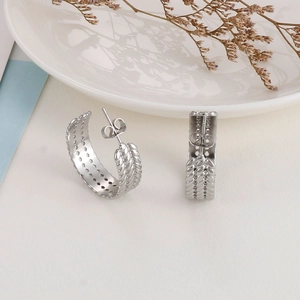Vintage silver thick hoop earrings with textured twisted metal design on a white background