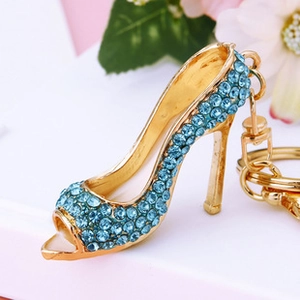 Macro shot of gold-plated high heel keychain with light blue rhinestones and spring clasp