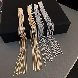 Detailed view of long metal tassel earrings in gold and silver with geometric triangles