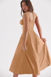 Detail view of the elegant tan midi dress with wide straps and flared skirt hem