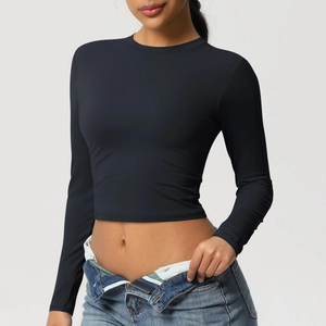 Détail d'un crop top noir à manches longues montrant la coupe ajustée et le tissu élastique