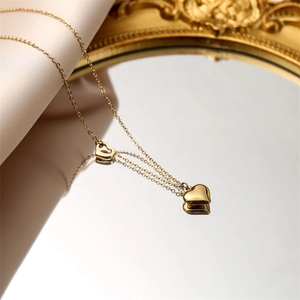 Détail macro du collier pendentif cœur doré sur soie avec reflet miroir