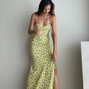 Side view of yellow floral maxi dress with high slit and adjustable spaghetti straps