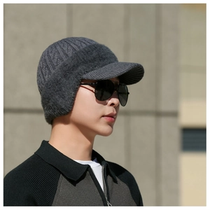 Close-up of men's winter knit hat with ear flaps and warm thick faux fur lining