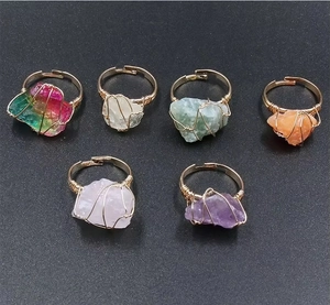 Détail de six bagues artisanales avec fil doré et pierres naturelles brutes variées