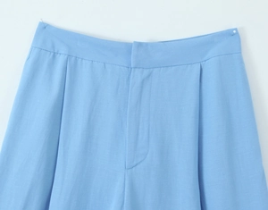 Close-up of blue linen high-waisted pants showing fabric texture and waist detail