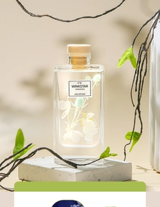 Close-up of reed diffuser with decorative dried flowers in a glass bottle on stone