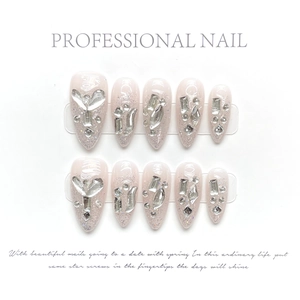 Detailed close-up of almond press-on nails with pink base, silver glitter and large rhinestones