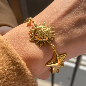 18K gold plated stainless steel sun and star charm bracelet worn on wrist for summer fashion