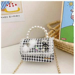 Close-up of girls houndstooth crossbody bag with pearl handle and rhinestone bear detail