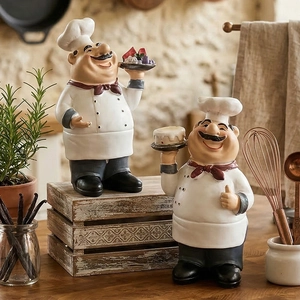 Set of two resin chef figurines holding a cake and fruit tray for rustic kitchen decor