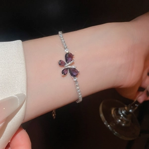 Gros plan d'un élégant bracelet de tennis en argent avec papillon en zircon violet au poignet