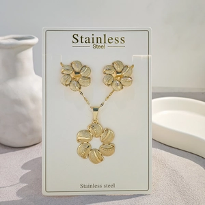 Detailed view of stylized golden flower necklace and earrings set made of stainless steel