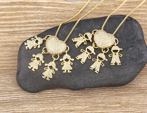 Dettaglio di ciondoli a cuore placcati oro 18k con charms per bambini e bambine su catene