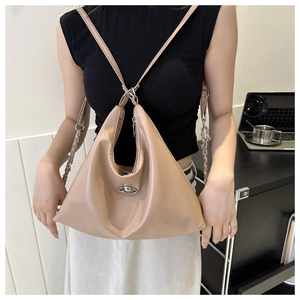 Detail of beige hobo bag with silver saturn logo metal buckle and chain strap