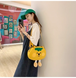 Detail of yellow persimmon cartoon crossbody bag with soft legs and adjustable strap