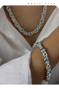Detailed shot of titanium steel Cuban chain jewelry set with turquoise blue bead accents