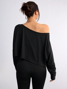 Rear view showing back details of a black off-shoulder long sleeve top and slim pants