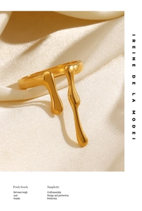 Detail of gold irregular liquid lava ring on silk fabric with elegant studio lighting