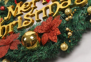 Macro detail of golden Merry Christmas sign and glitter ornaments on Christmas wreath