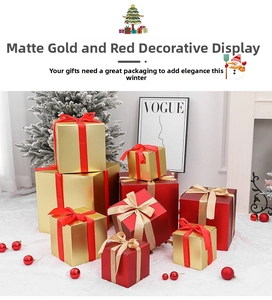 Close-up of matte red and gold holiday gift box set with satin ribbons on white faux fur