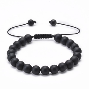 Detailed macro of handmade black matte lava stone bracelet with adjustable braided cord