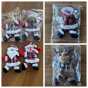 Detail view of plush Christmas ornaments with Santa, snowman and deer in plaid fabric