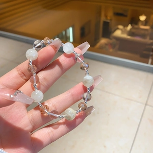 Close-up of elegant chalcedony and crystal beaded bracelet with silver spacers on wrist