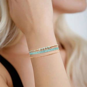 Three-piece bohemian layered bracelet set with gold chain, woven strap and blue beads