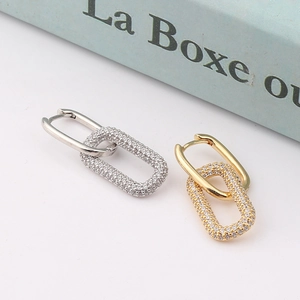 Detail shot of silver and gold U-shape earrings featuring sparkling cubic zirconia stones