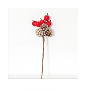Detail of red Christmas berries with mini pine cones and snow frosted tips on stems
